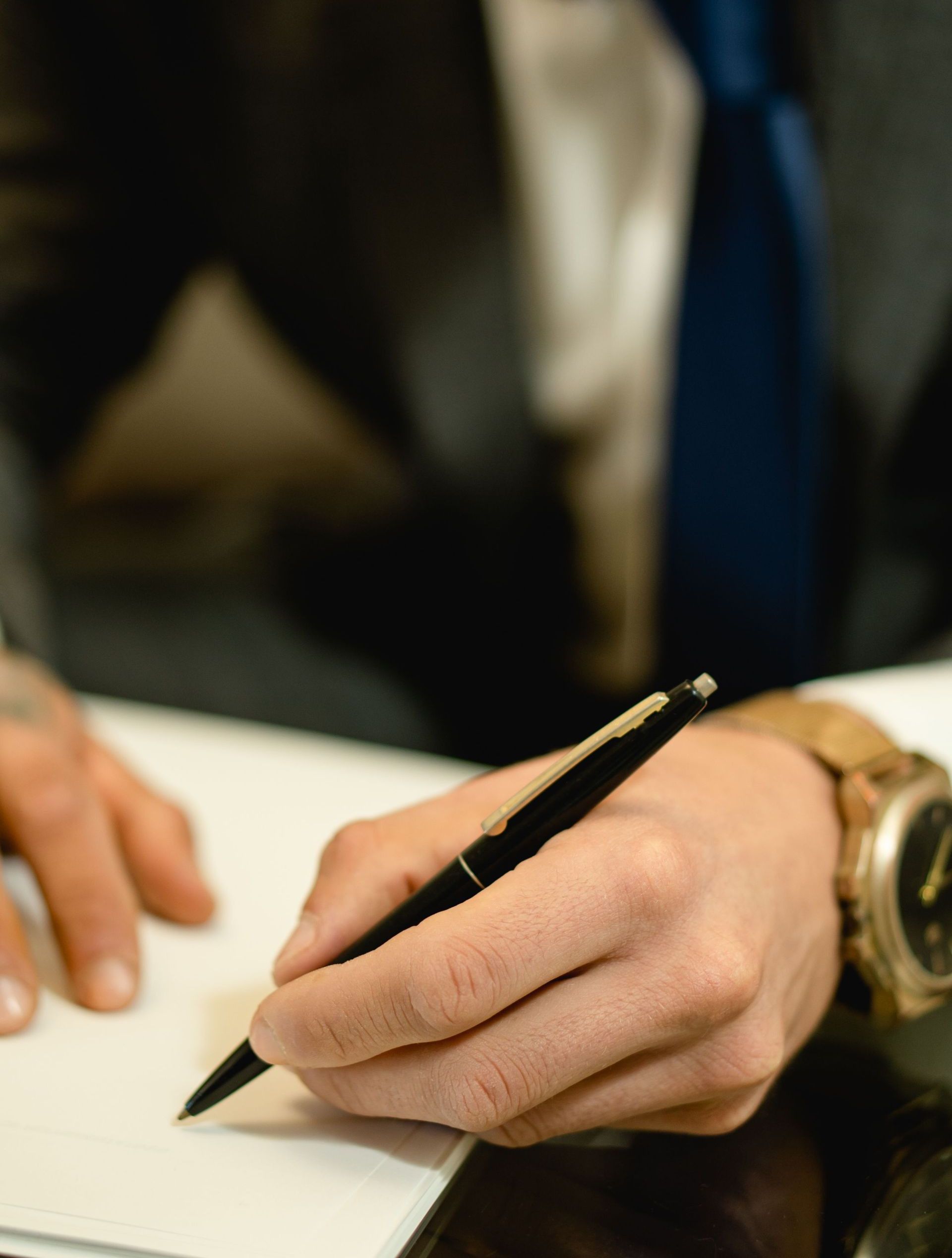 Close-up of hand signing a legal contract with a pen. Ideal for business and legal themes.